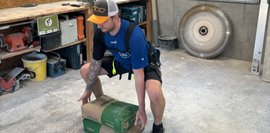 Exoskelett im Einsatz: Heben Ein Mann bereit sich vor 2 Säcke Zement zu heben