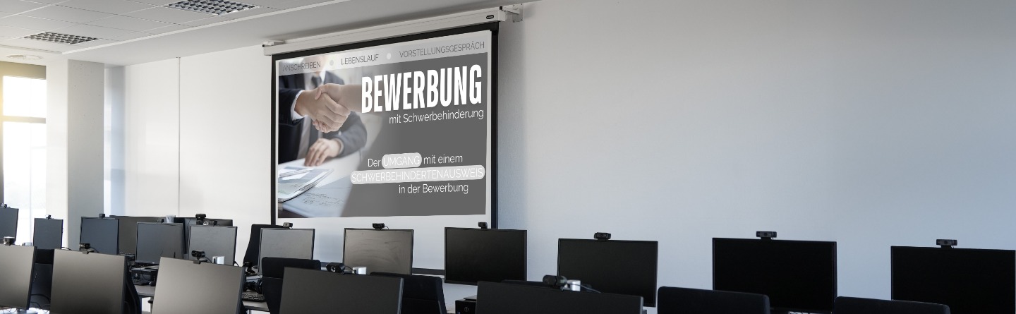 Man sieht einen Raum mit vielen Computern und die Projektion einer Präsentation vorne im Raum.