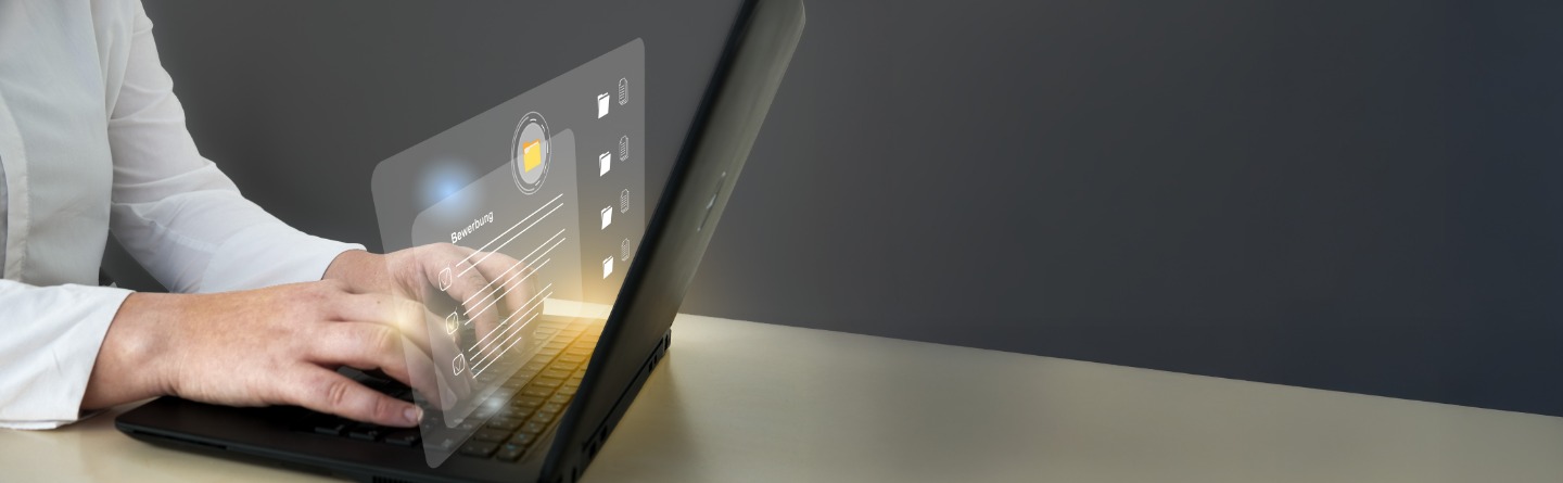 Person mit Laptop und transparenter Benutzeroberfläche Person arbeitet am Laptop. Die Hände sind auf der Tastatur. Man sieht eine virtuelle Oberfläche.