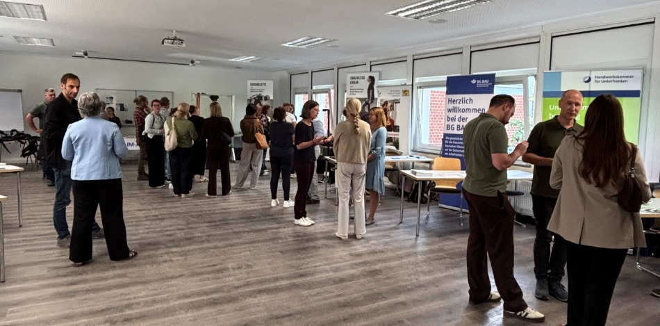 Das Bild zeigt den Ausstellungsraum mit den Besuchern der Veranstaltung. 