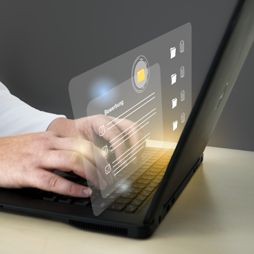 Person arbeitet am Laptop. Die Hände sind auf der Tastatur. Man sieht eine virtuelle Oberfläche.