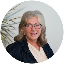 Das Bild zeigt eine Frau neben einer Blume.