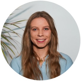 Das Bild zeigt eine Frau die neben einer Blume steht.