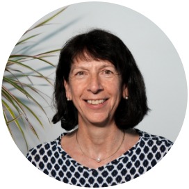 Claudia Werner-Herre Das Bild zeigt eine Frau die neben einer Blume steht.