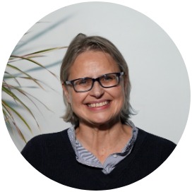 Das Bild zeigt eine Frau die neben einer Blume steht.