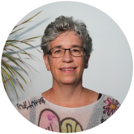 Doris Kaufmann Das Bild zeigt eine Frau die neben einer Blume steht.