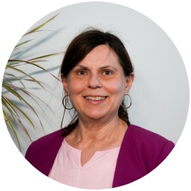 Elke Rinneck Das Bild zeigt eine Frau die neben einer Blume steht.