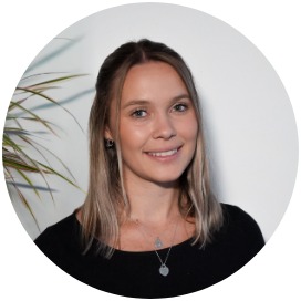 Katharina Derleth Das Bild zeigt eine Frau die neben einer Blume steht.