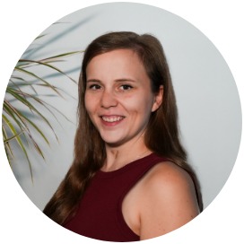 Marion Endres Das Bild zeigt eine Frau die neben einer Blume steht.