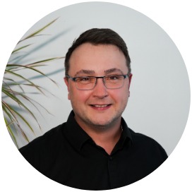 Nico Kleinstück Das Bild zeigt einen Mann der neben einer Blume steht.