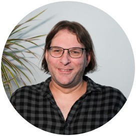 Robert Schleicher Das Bild zeigt einen Mann der neben einer Blume steht.