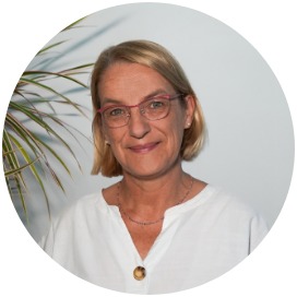 Simone Dittmann Das Bild zeigt eine Frau die neben einer Blume steht.