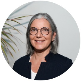 Das Bild zeigt eine Frau die neben einer Blume steht.