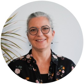 Tanja Scheuring Das Bild zeigt eine Frau die neben einer Blume steht.