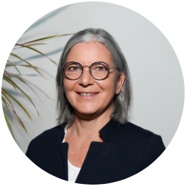 Das Bild zeigt eine Frau die neben einer Blume steht.