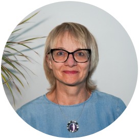 Yvonne Soul Das Bild zeigt eine Frau die neben einer Blume steht.